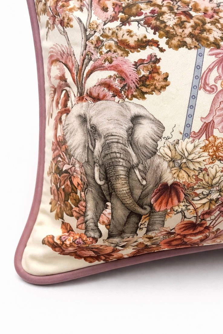 Square blush pink and cream velvet cushion cover with botanical and animal print, featuring elephants, swans and a tiger, finished with dusty pink piping.