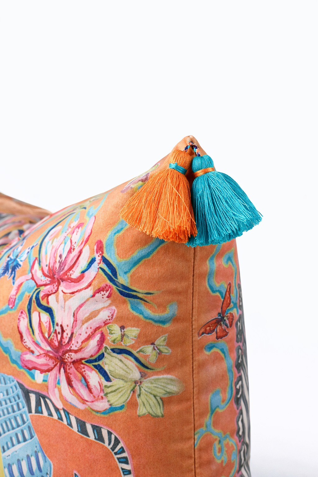 Orange velvet cushion cover with illustrated zebra, floral motifs and blue tassels, square decorative cushion.