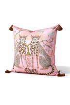 Pink velvet cushion cover with two illustrated cheetahs, sunburst halos, birds, floral branches and brown tassel corners