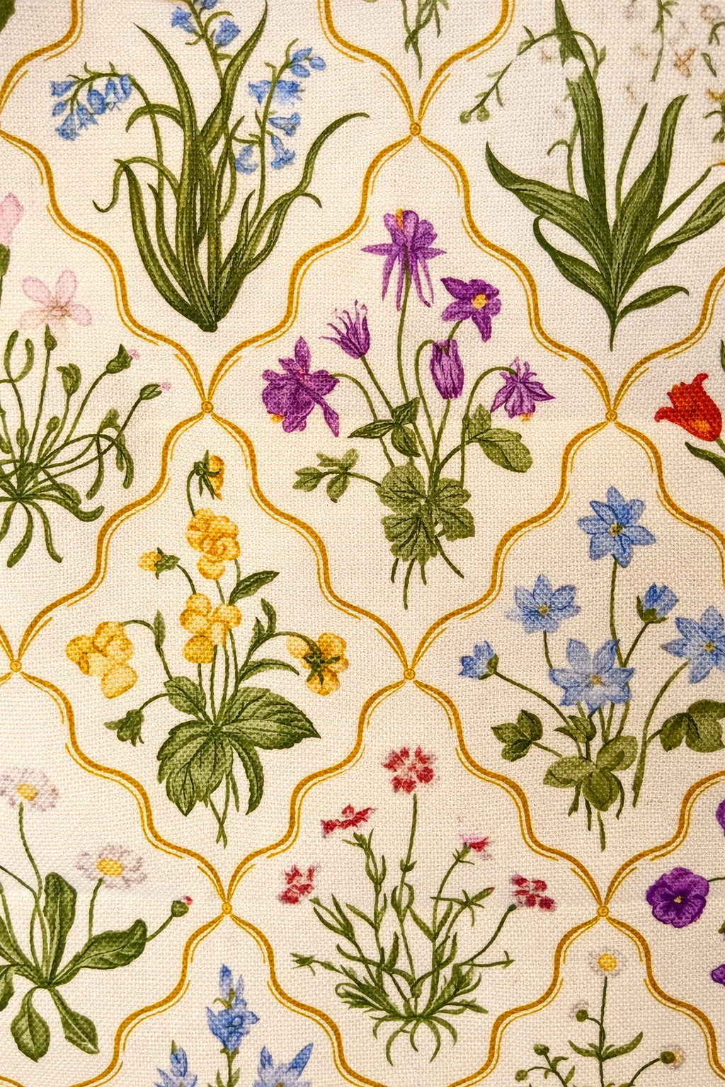 Cream square cushion with multicolour botanical flowers in a repeating trellis lattice pattern