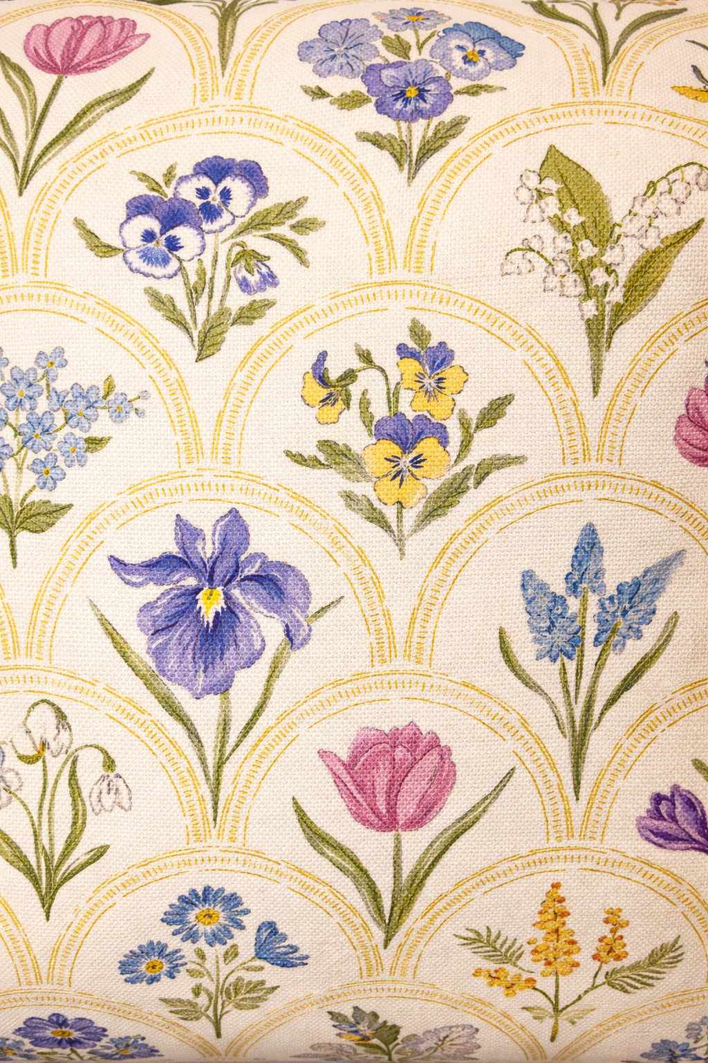 Cream square cushion with multicolour botanical flowers in a repeating scallop pattern