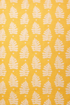 Yellow square cushion with a repeating white leaf botanical motif