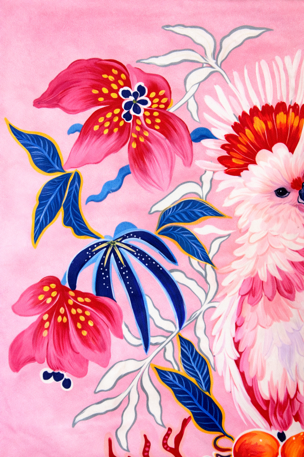 Square pink velvet cushion cover featuring illustrated cockatoos, floral motifs and red tassel corners