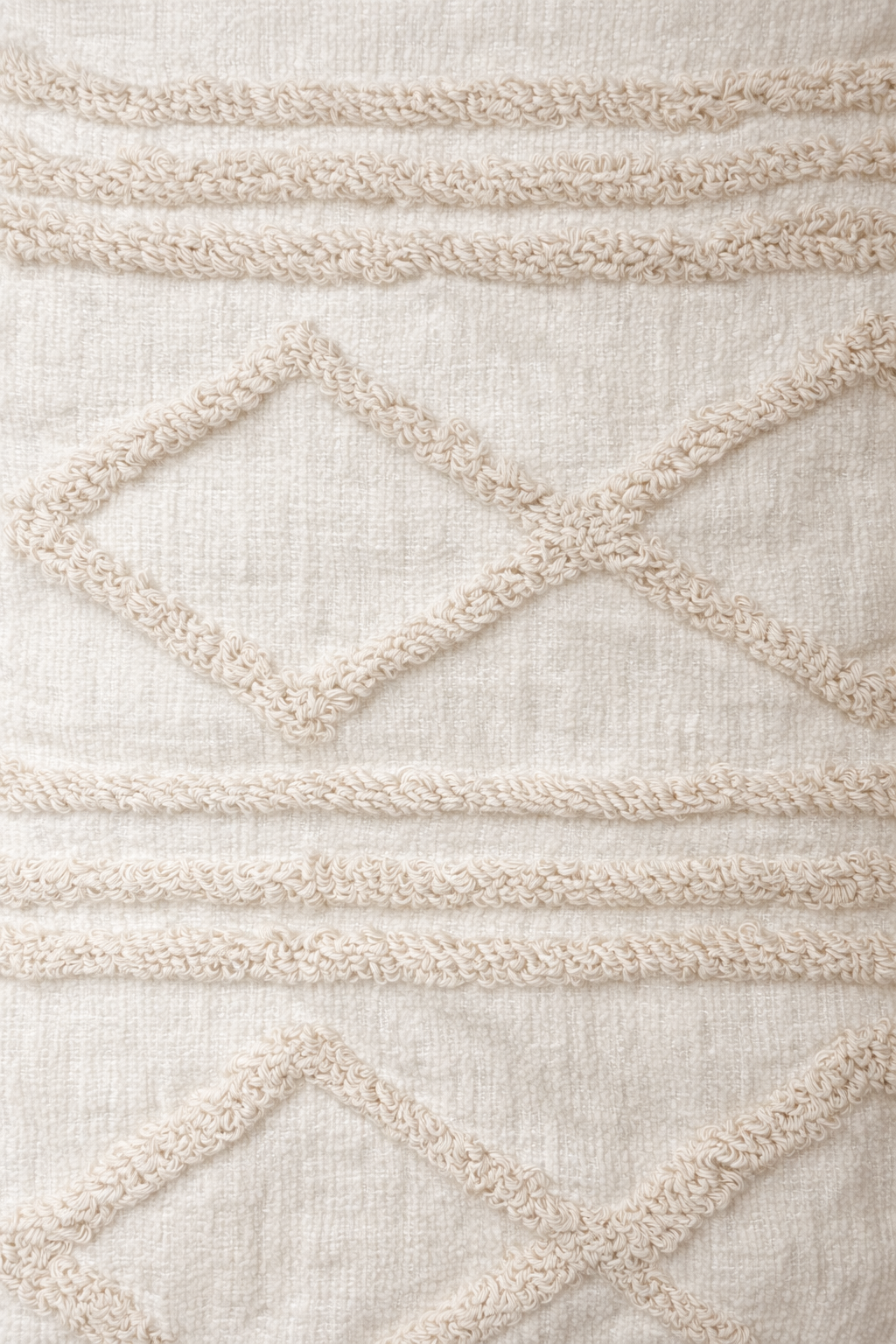 Beige square cushion with raised diamond tufted bands and tassel corners