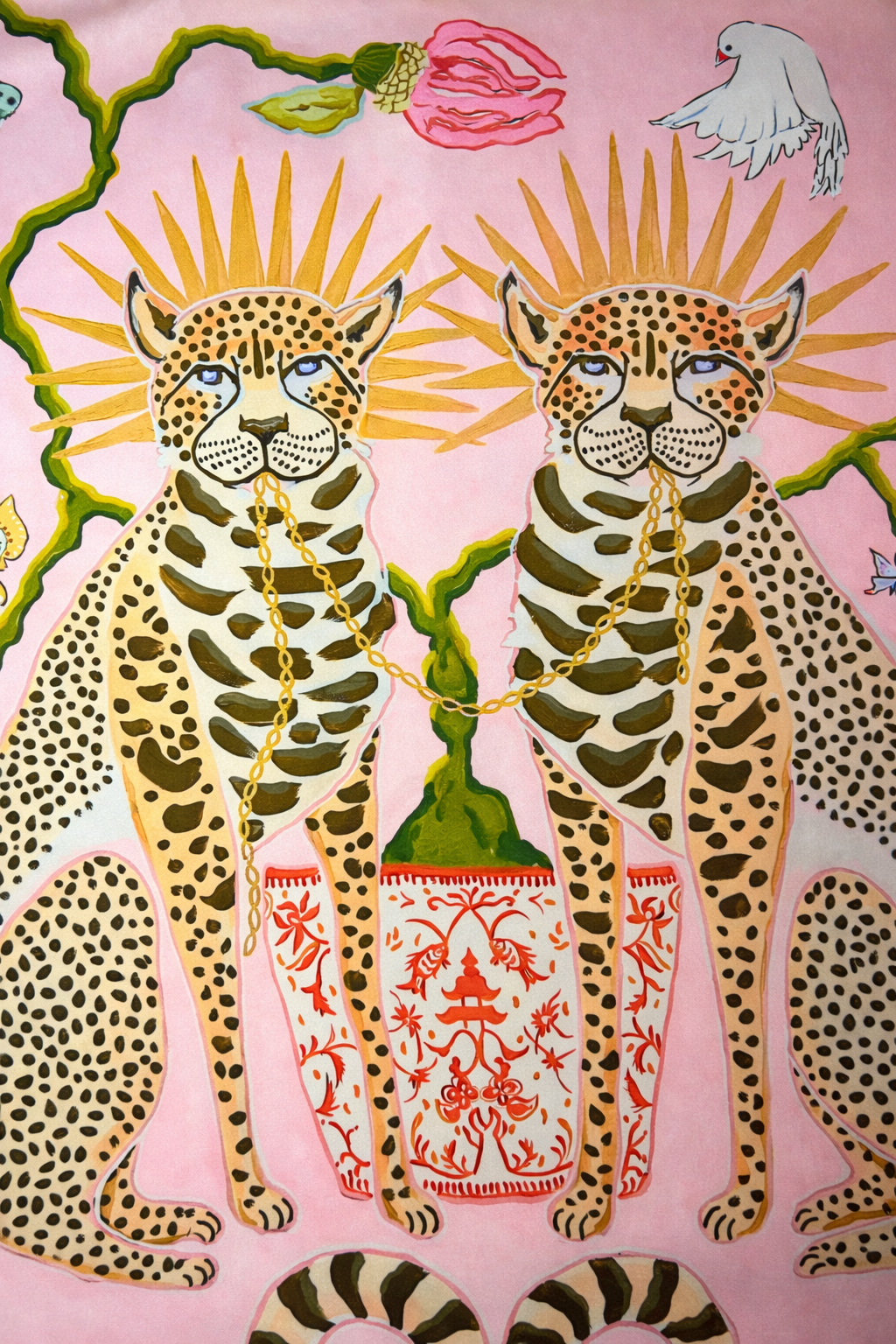 Pink velvet cushion cover with two illustrated cheetahs, sunburst halos, birds, floral branches and brown tassel corners