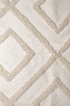 Beige square cushion with raised diamond tufted pattern and tassel corners