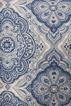 Blue and ivory square cushion with a repeating ornamental medallion pattern