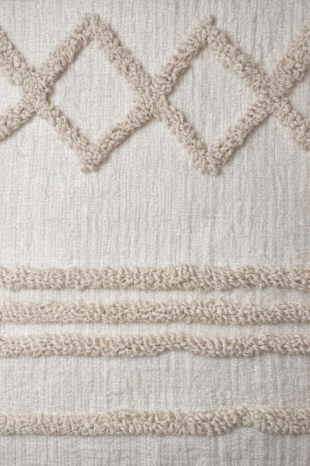 Beige square cushion with tufted geometric patterns and tassel corners