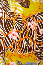 Yellow velvet cushion cover with illustrated zebra, floral branches, snake motif and pink corner tassels