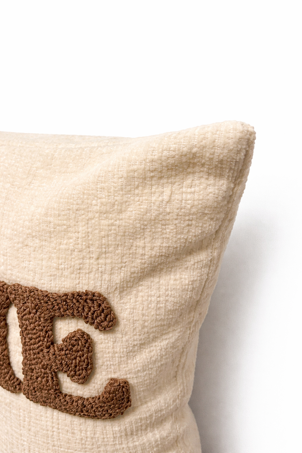 Ivory rectangular cushion with HOME appliqué lettering in raised stitched design