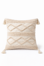 Beige square cushion with raised diamond tufted bands and tassel corners