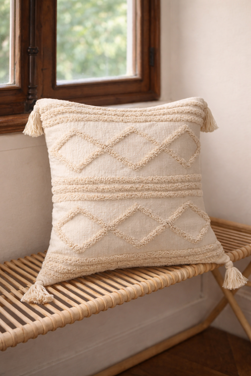 Beige square cushion with raised diamond tufted bands and tassel corners