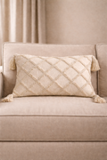Beige rectangular cushion with diamond tufted detailing and tassel corners