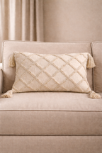 Beige rectangular cushion with diamond tufted detailing and tassel corners