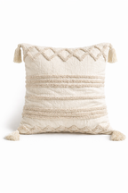 Beige square cushion with tufted geometric patterns and tassel corners