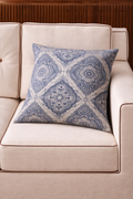 Blue and ivory square cushion with a repeating ornamental medallion pattern