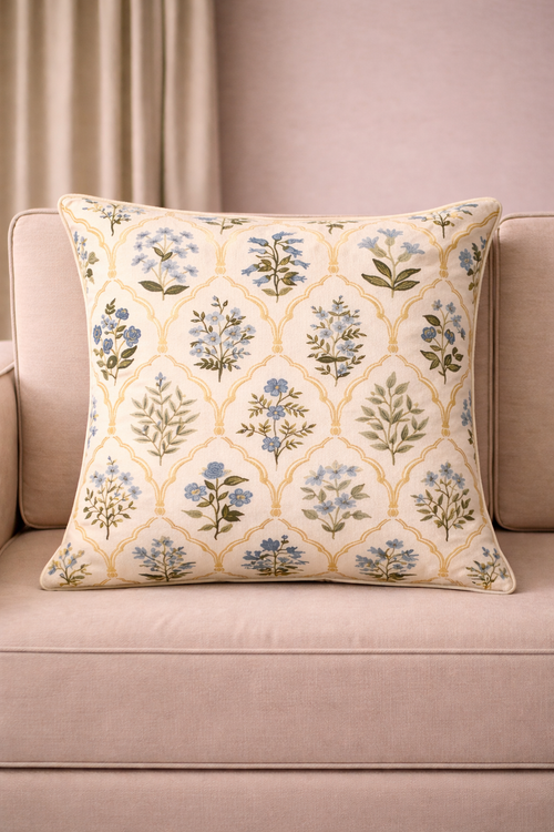 Cream square cushion with blue floral motifs and repeating arched lattice pattern