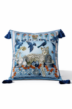 Square blue velvet cushion cover featuring a leopard, birds and decorative garden motifs with tassel corners
