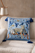 Square blue velvet cushion cover featuring a leopard, birds and decorative garden motifs with tassel corners