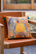 Orange velvet cushion cover with illustrated zebra, floral motifs and blue tassels, square decorative cushion.
