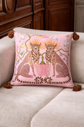 Pink velvet cushion cover with two illustrated cheetahs, sunburst halos, birds, floral branches and brown tassel corners