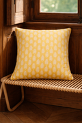 Yellow square cushion with a repeating white leaf botanical motif