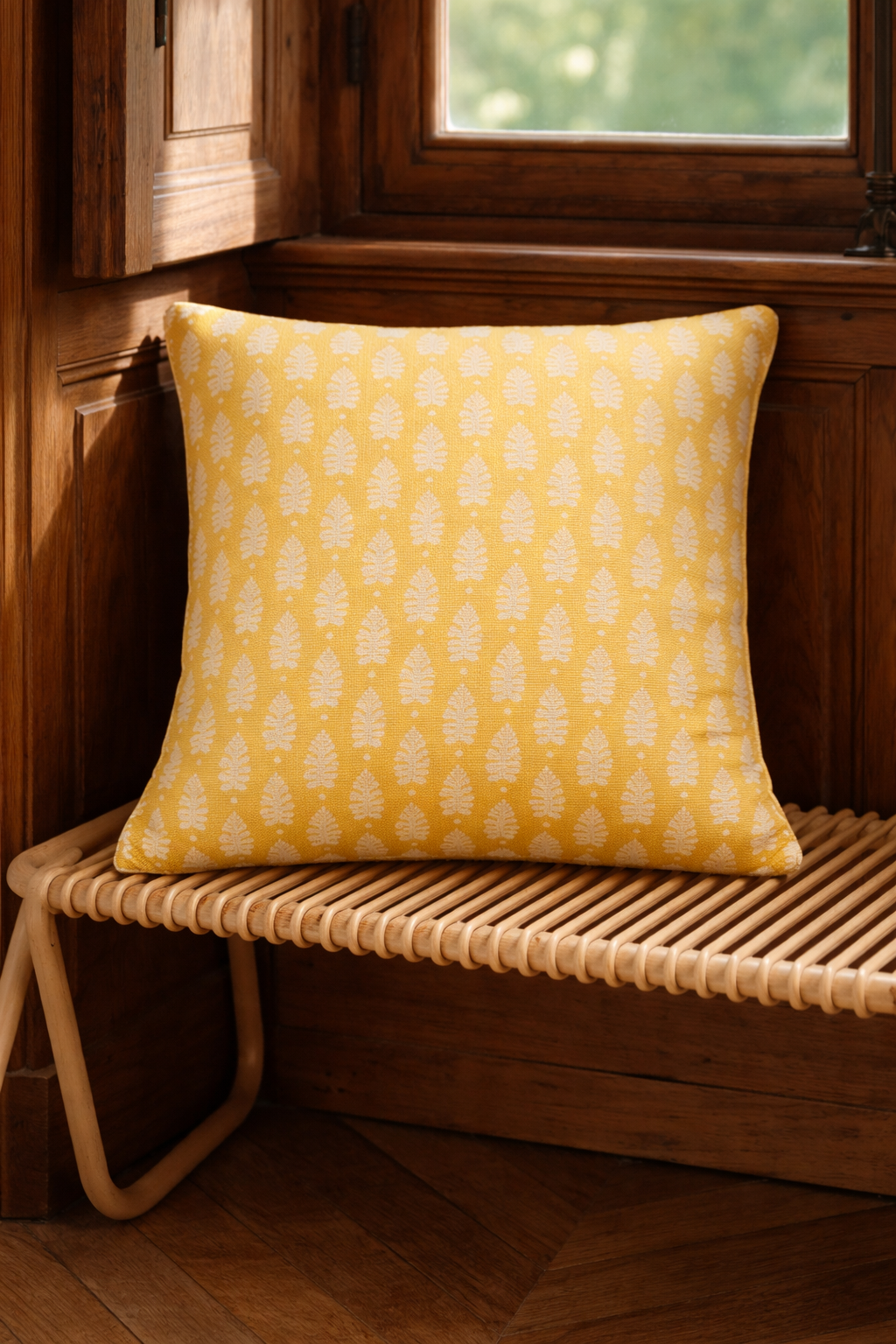 Yellow square cushion with a repeating white leaf botanical motif