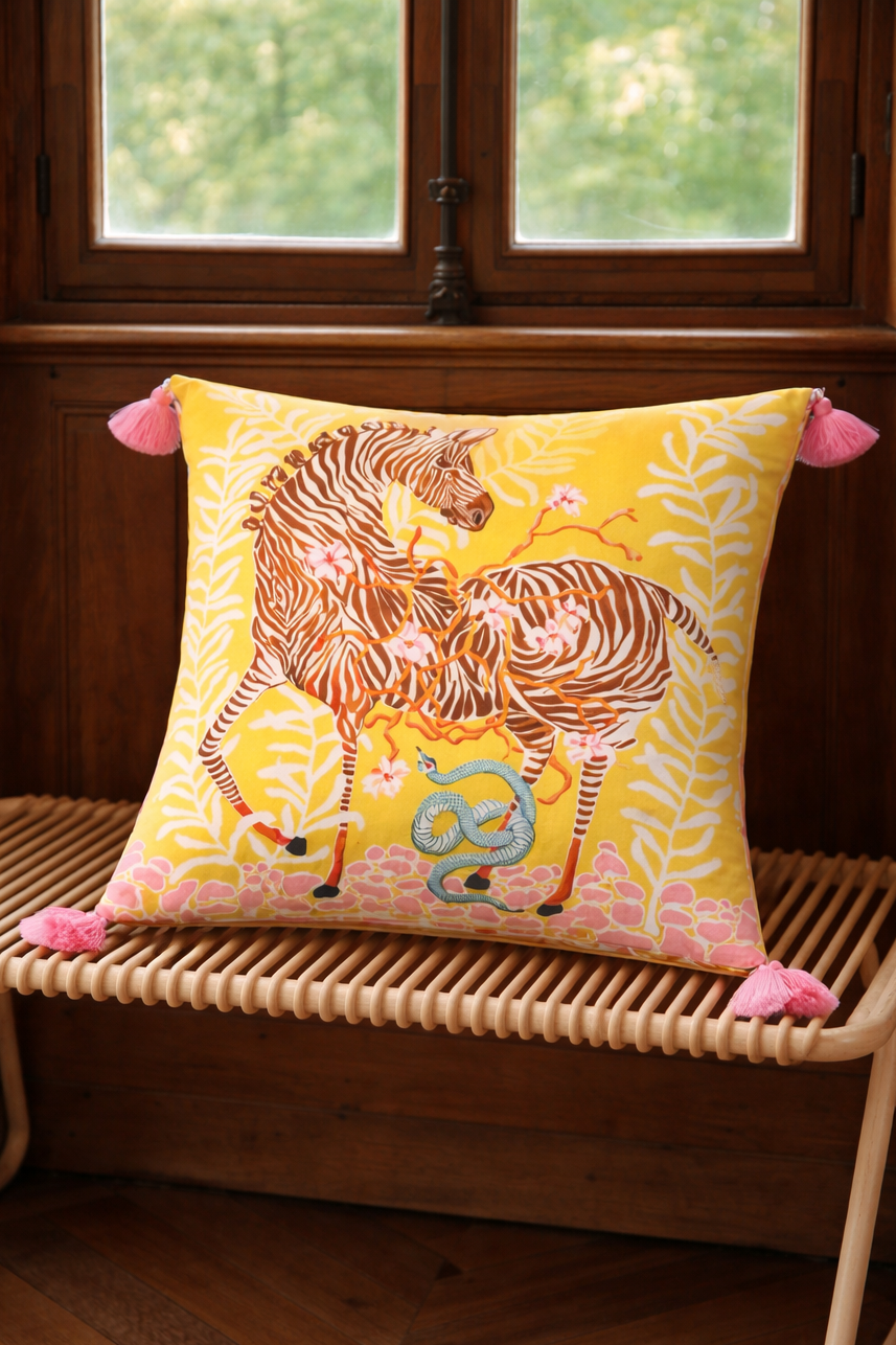 Yellow velvet cushion cover with illustrated zebra, floral branches, snake motif and pink corner tassels